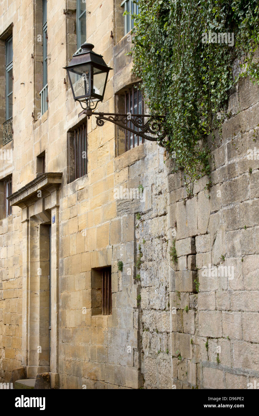 Wrought iron street lamp protruding from medieval sandstone buildings in charming Sarlat, Dordogne region of France Stock Photo