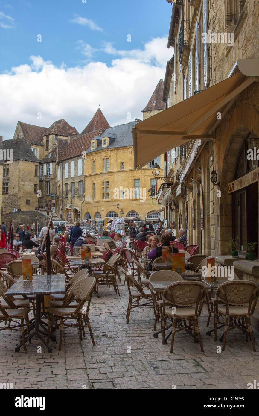 Tourists eating at an outdoor cafe in Liberty Plaza in the center of charming Sarlat, Dordogne region of France Stock Photo