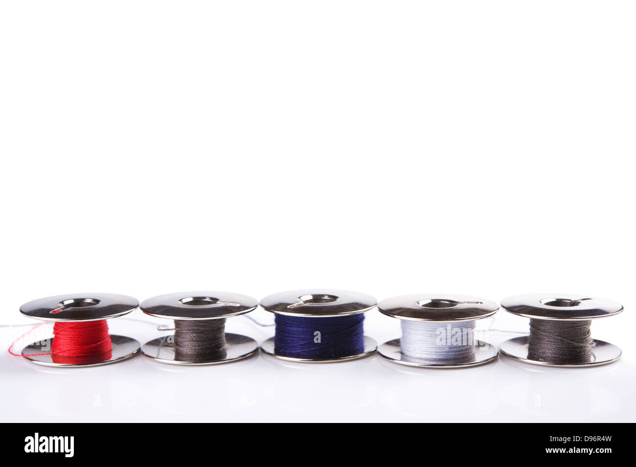 Some metal spools with multicoloured threads isolated on white Stock