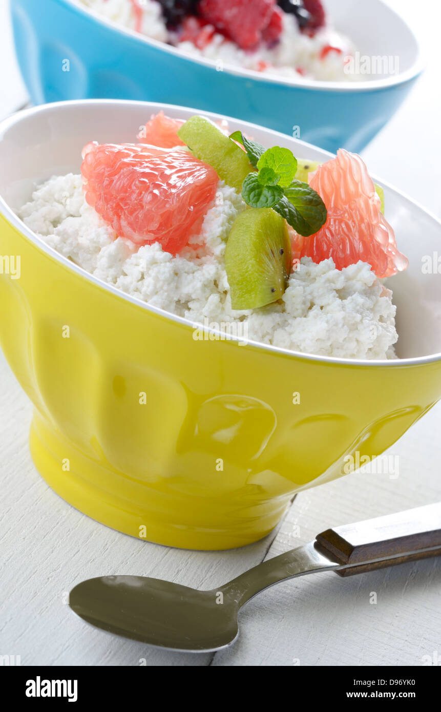 Cottage cheese in yellow bowl with kiwi, grapefruit and mint Stock