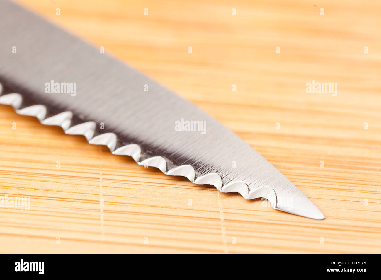 Shiny Metal knife on a wooden cutting board Stock Photo