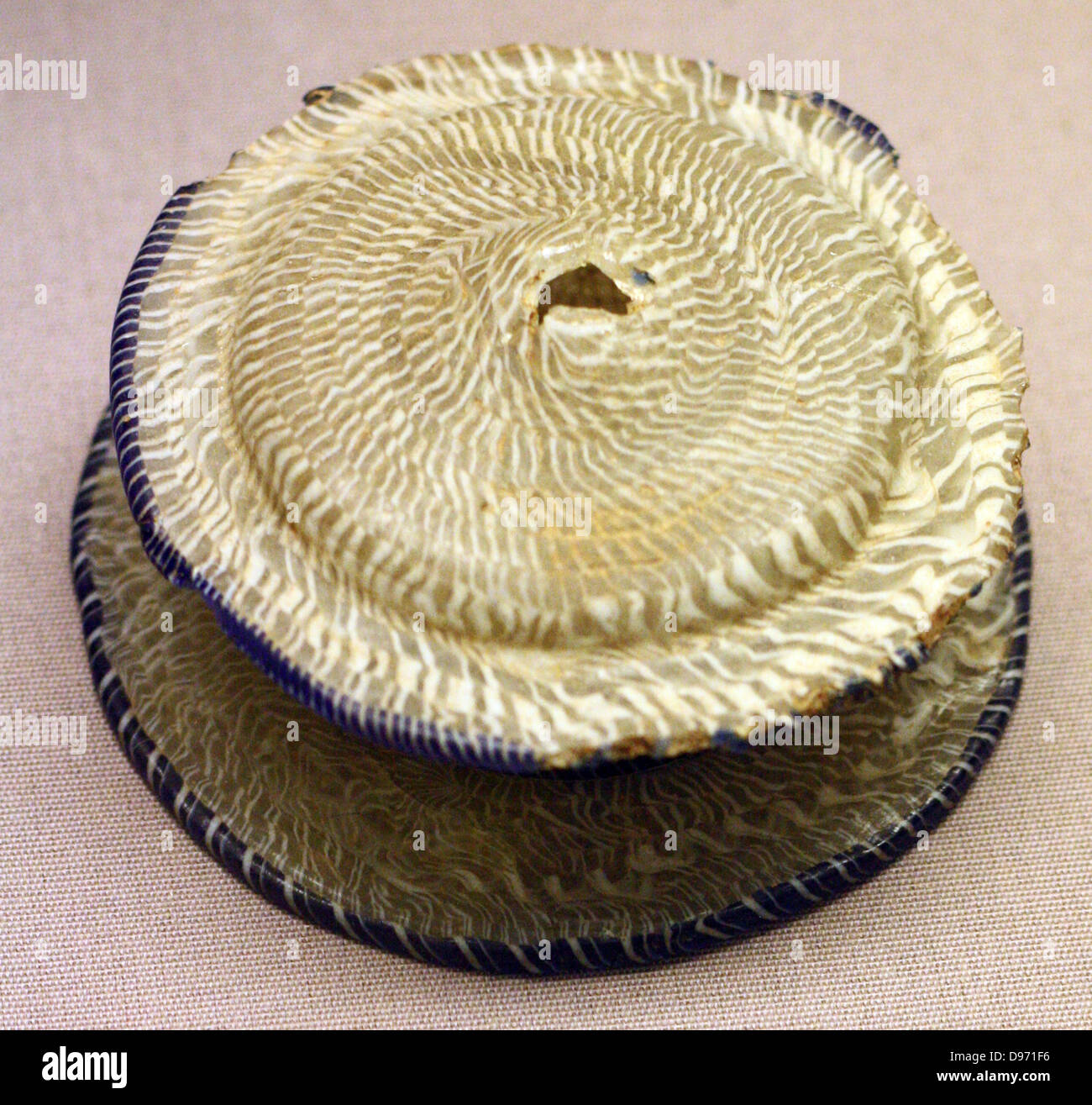 Lidded box of network mosaic glass, knob of lid missing. Made in the eastern Mediterranean, about 150-50 BC From Crete The box and lid are built up of canes of colourless glass twisted with two trails of opaque white and are shaped by the slumping process. The twisted canes of blue and white were attached at different stages. Stock Photo
