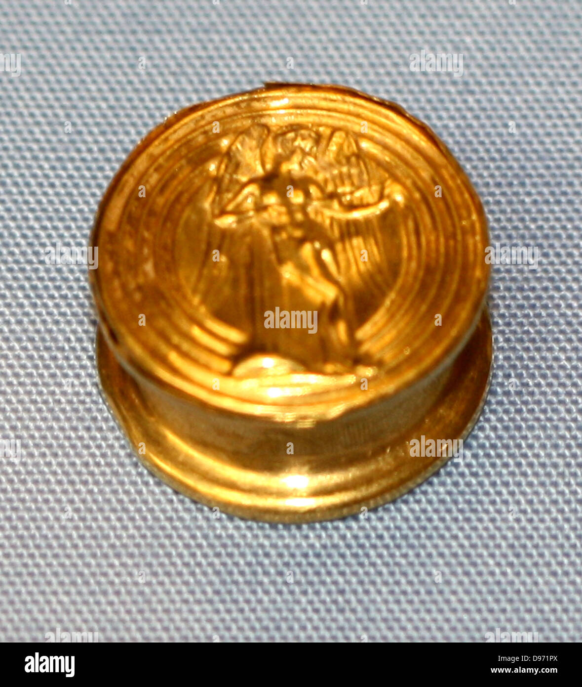 Gold spool-shaped earring On one side Eros leans against a pillar as he plays with his magic spinning toy (iynx); on the other, one of the daughters of Nerus rides on a dolphin as she brings a new helmet for Achilles. Such earrings, which require a large hole in the ear-lobe, were very popular on Rhodes and in Lydia. Stock Photo