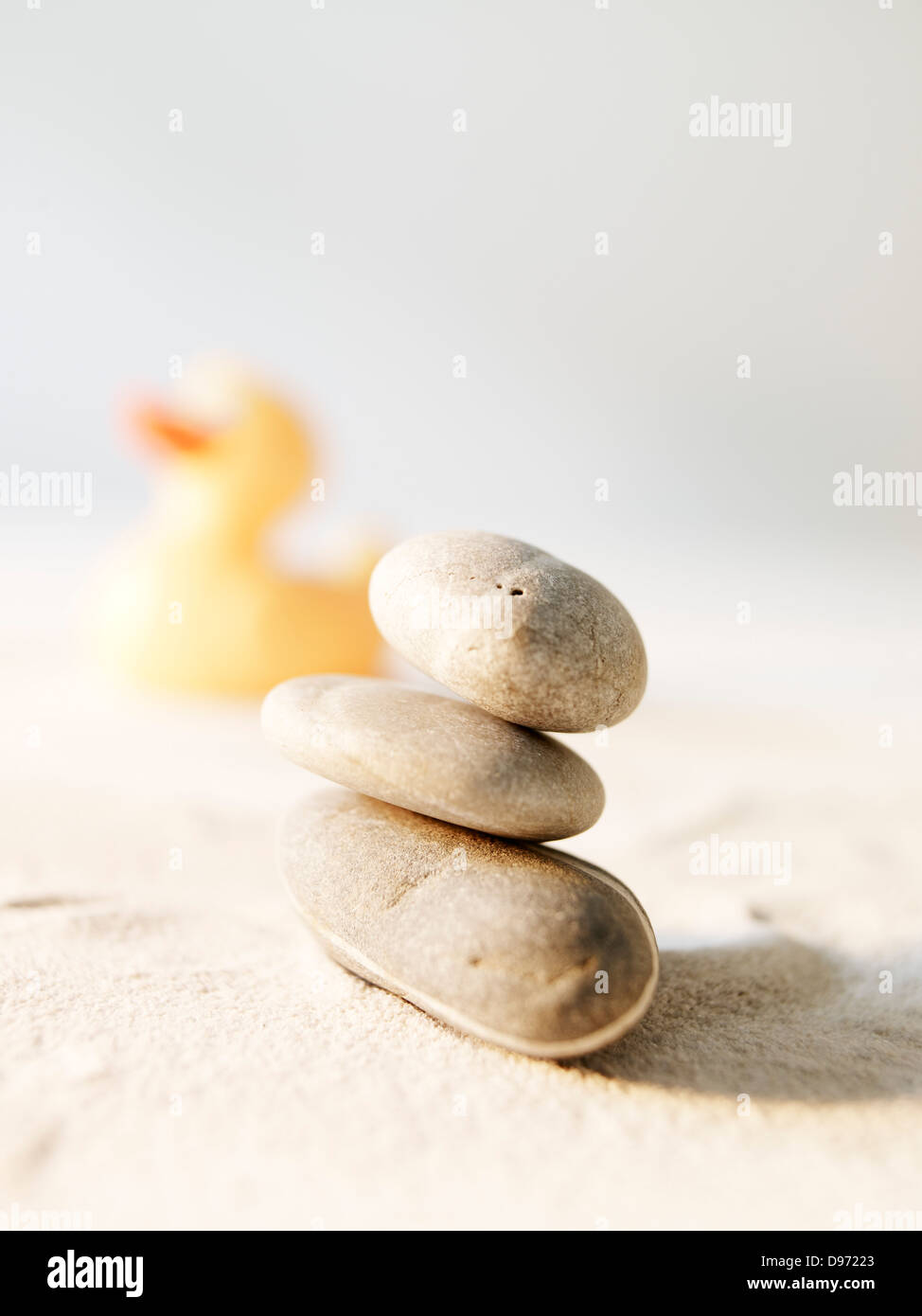 Stack stones and rubber duck on sand Stock Photo - Alamy