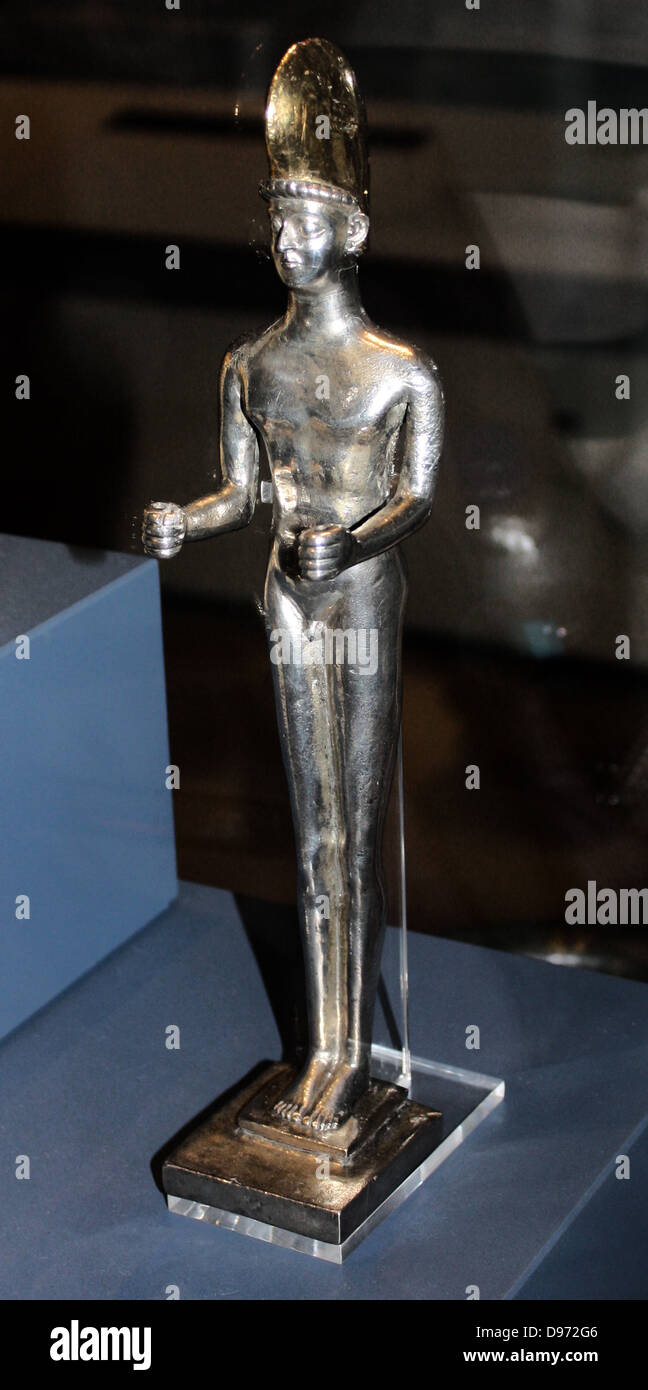 Votive statuettes. The styles of these statuettes are all very different, but it is likely that they were all intended as votive offerings. One shows a bearded man holding a bundle of wigs or barsom, used by Zoroastrian priests for their sacred fire. The two small gold statuettes wear 'Median dress' of a belted tunic and trousers with embroidered overcoats thrown over their shoulders.5th - 4th BC Stock Photo