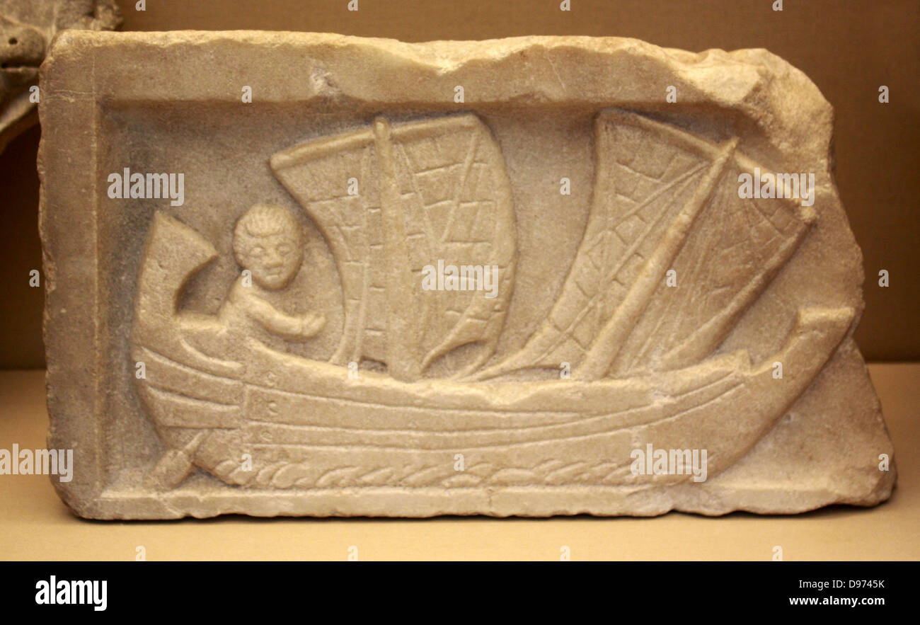 Marble relief showing a man sailing a corbita (a small coastal vessel with two masts) Roman, found at Carthage and probably made in Africa Proconsularis (Tunisia) about AD 200. The sails of the boat would probably be made of cloth, with leather reinforcements at the corners, Large amounts of trading was carried out by a small boats such as this which went from harbour to harbour hugging the coast. Stock Photo