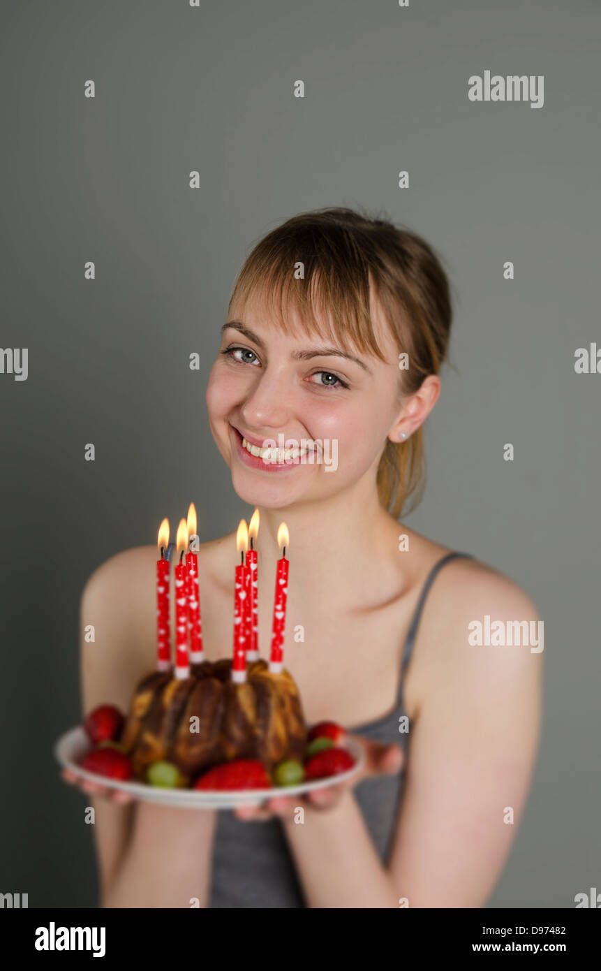 Portrait of young woman holding birthday cake, smiling Stock Photo - Alamy