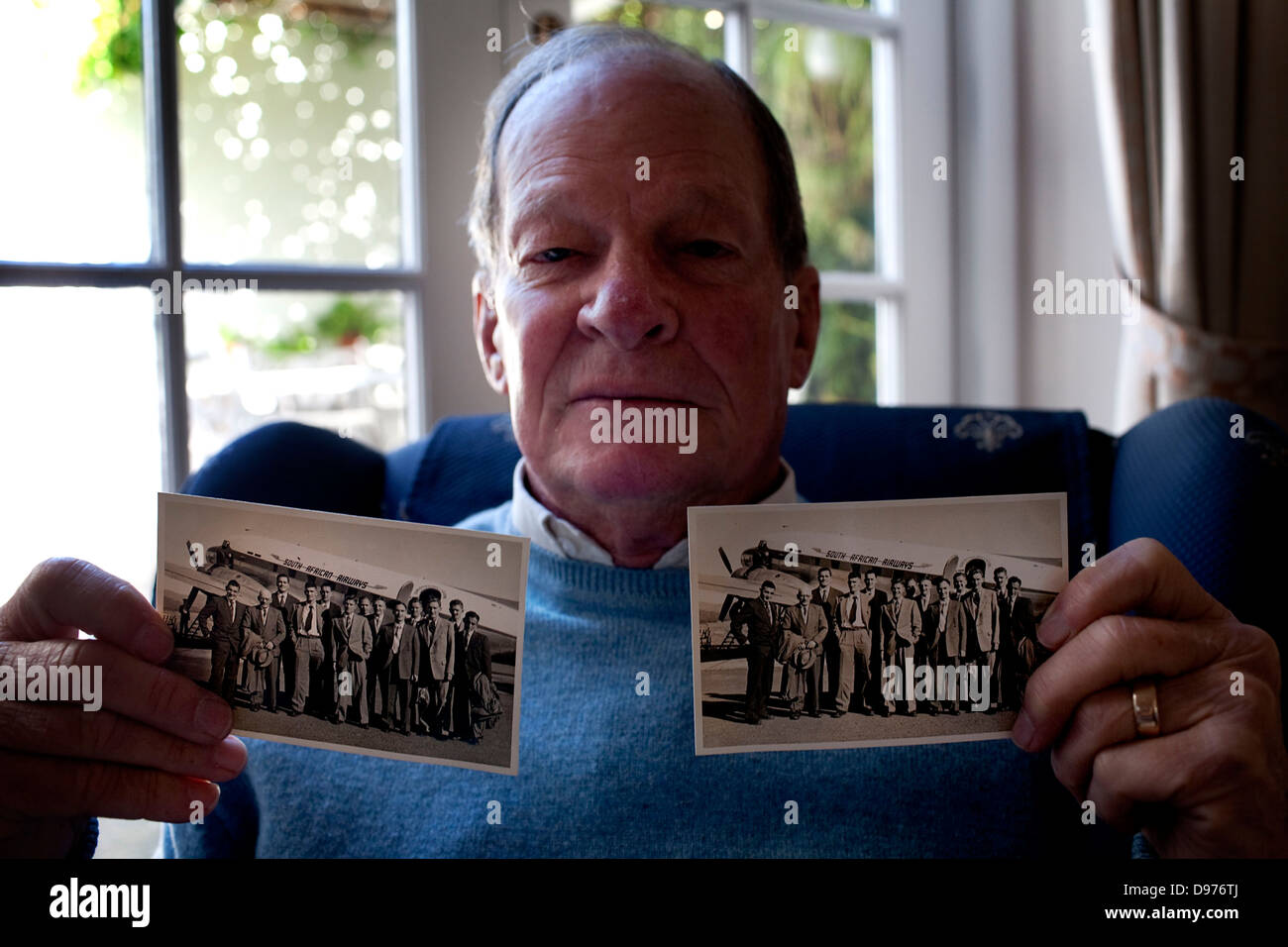 Eric Logan home in Newlands Cape Town South Africa He holds up two Black White photographs springbok soccer team team were on Stock Photo