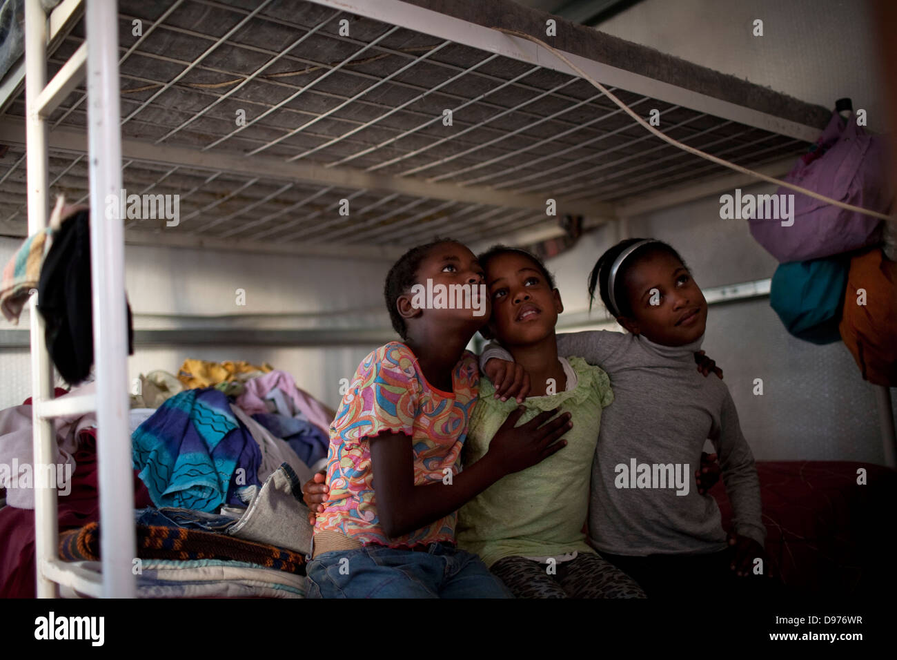 <p>Jeanette Walker's children friend watch programme on television in one-bedroom home in Blikkiesdorp in Cape Town South Stock Photo