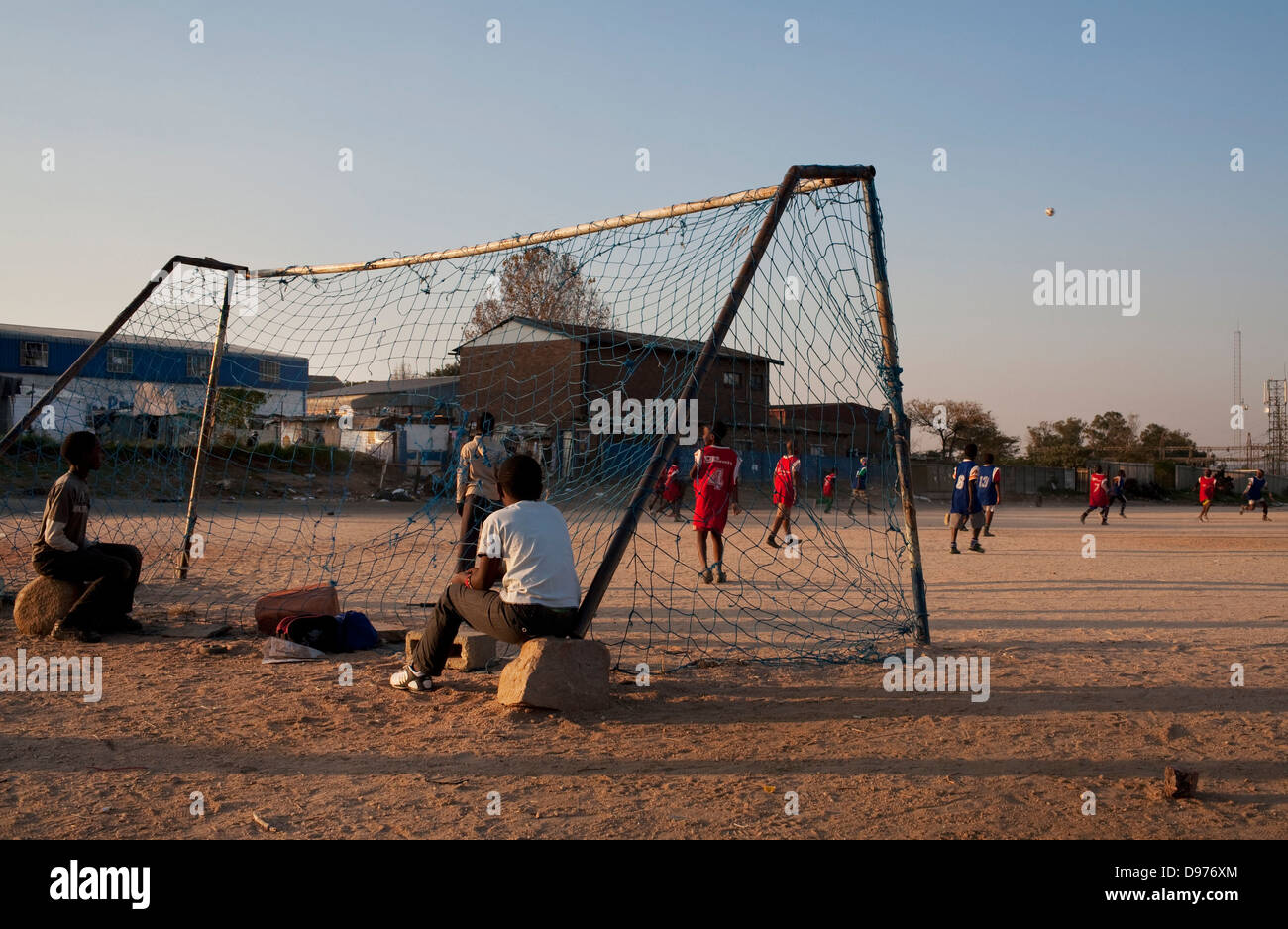 <p>Children play football local football ground next to old ice-cream factory in Alexandra township Johannesburg.</p> Stock Photo