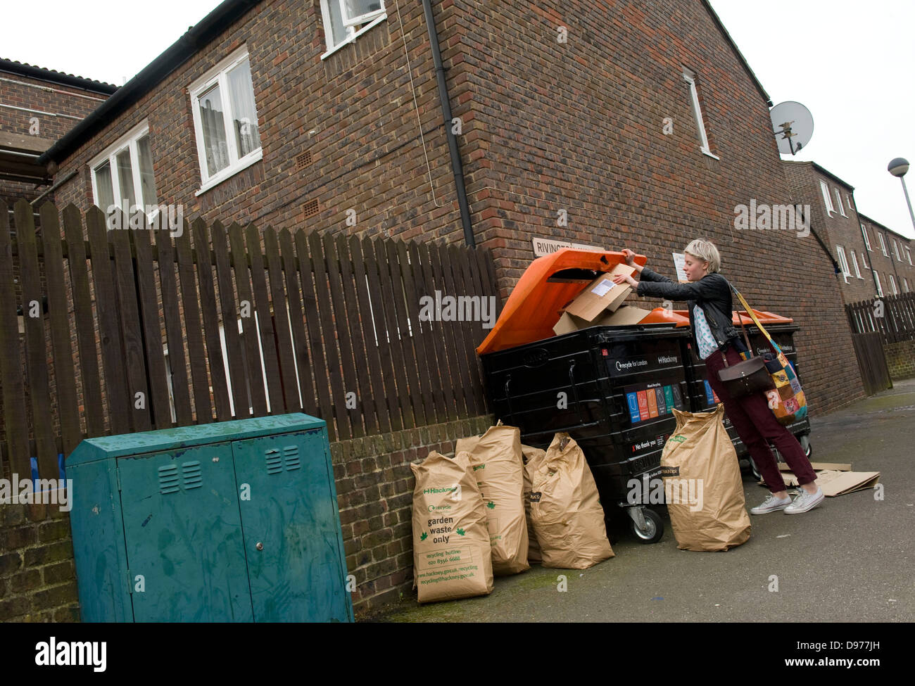 An attractive trendy young woman recycling cardboard boxes in Broadway