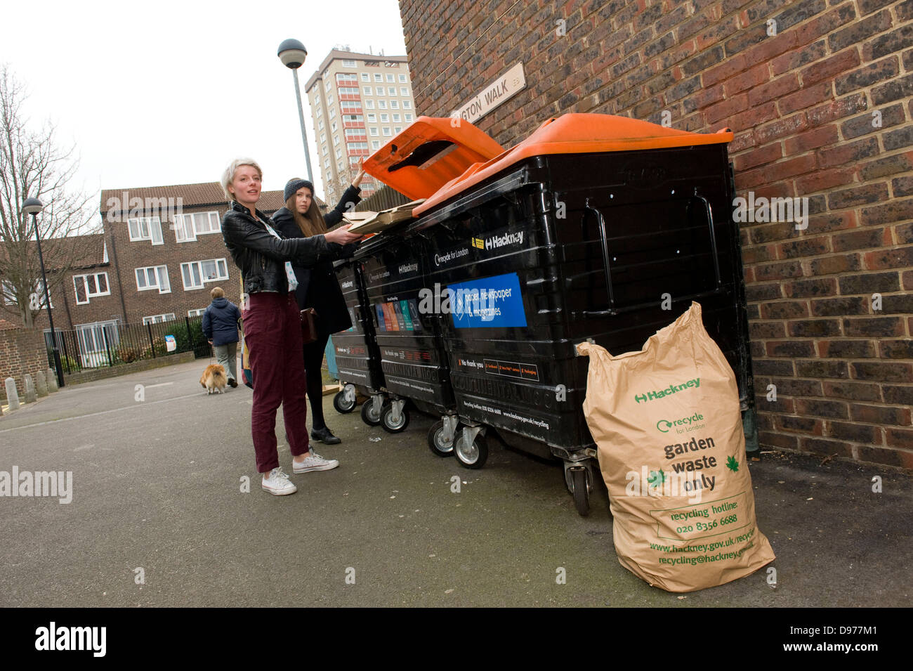 An attractive trendy young woman recycling cardboard boxes in Broadway