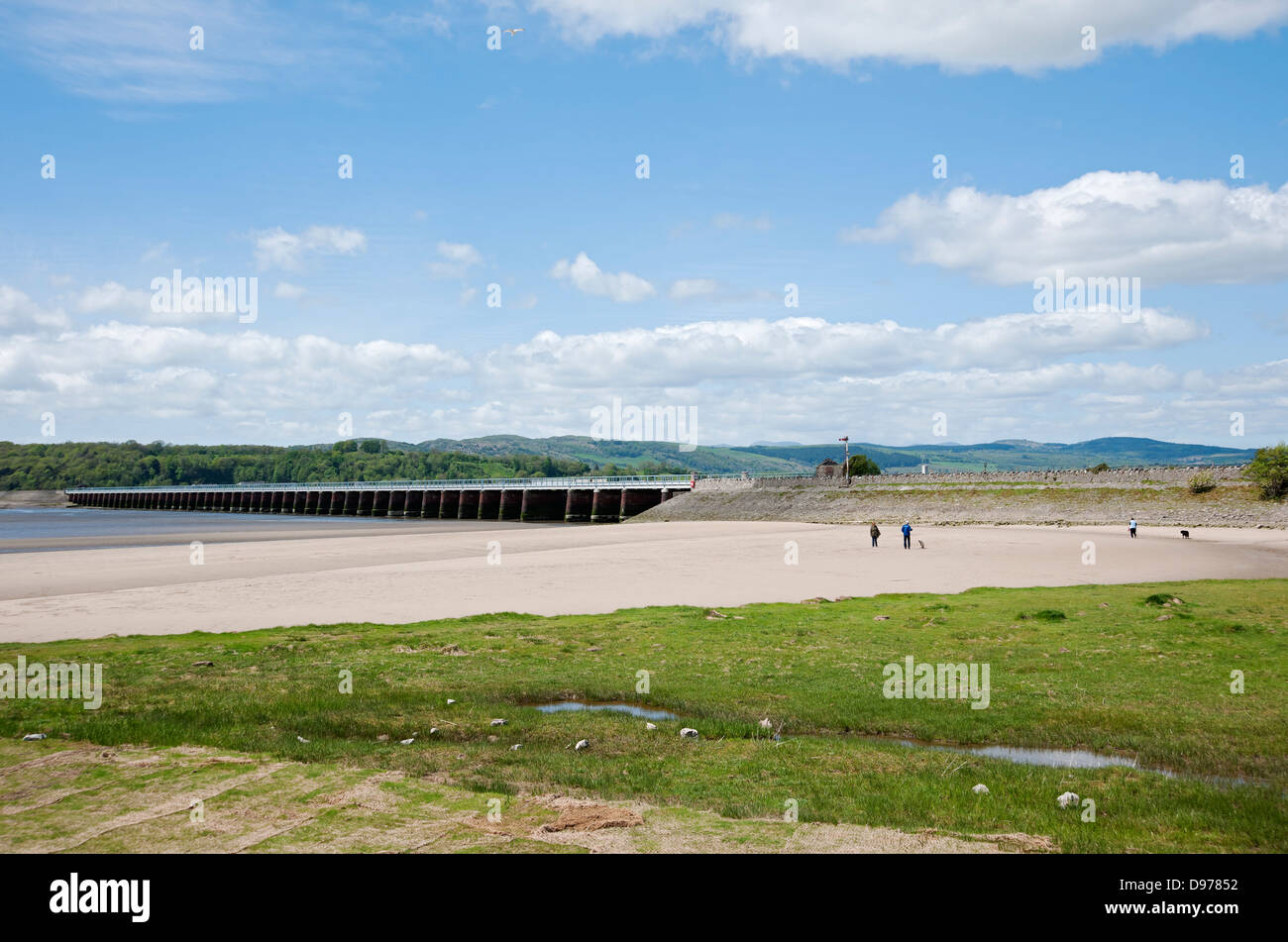 People tourists visitors on beach near Arnside viaduct bridge across the Kent Estuary Arnside Cumbria England UK United Kingdom GB Great Britain Stock Photo