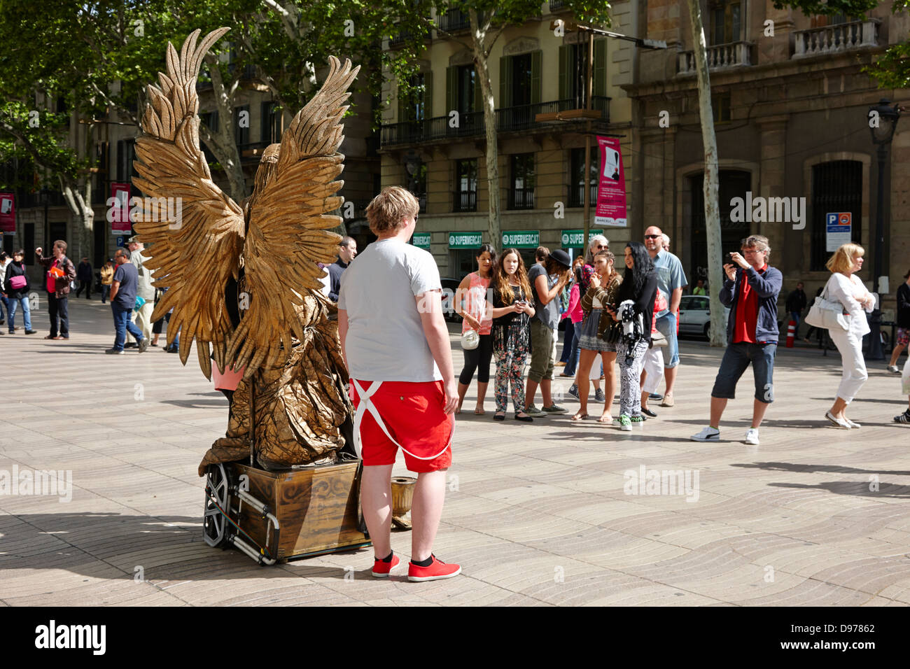 tourists pose for photos with living statue street performer on la rambla barcelona catalonia spain Stock Photo