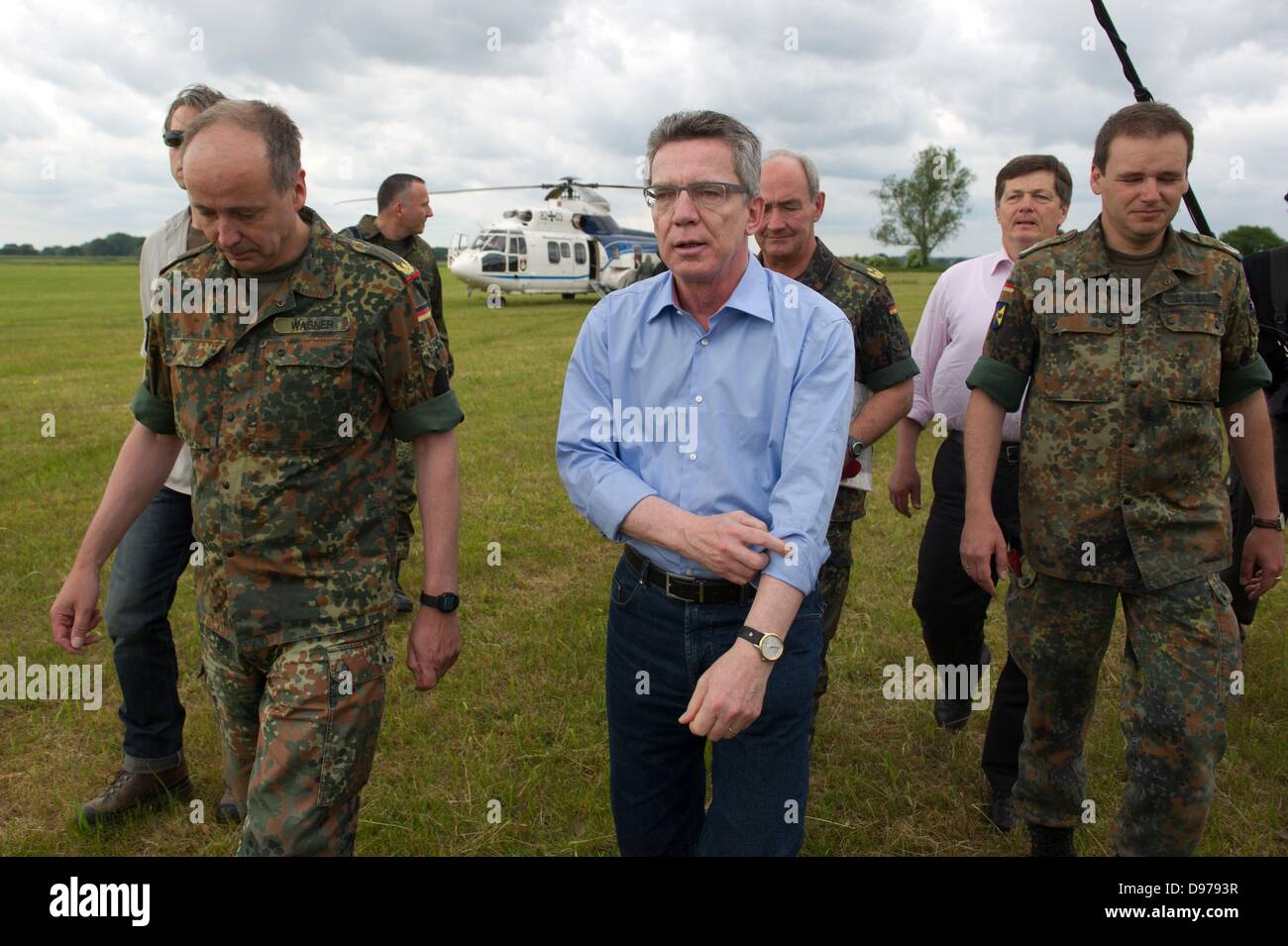 Penkefitz, Germany. 13th June, 2013. German Defence Minister Thomas de Maiziere visits soldiers of the Bundeswehr at a dike near Penkefitz, Germany, 13 June 2013. Soldiers of the logistics battalion 141 from Neustadt am Ruebenberge reinforced dikes with sandbags in the area Luechow-Dannenberg. Photo: Sebastian Kahnert/dpa/Alamy Live News Stock Photo