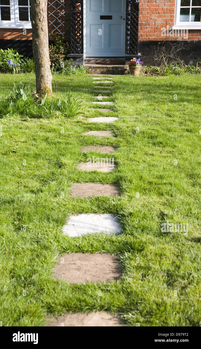 Garden path leading past apple tree to front door of house, UK Stock Photo