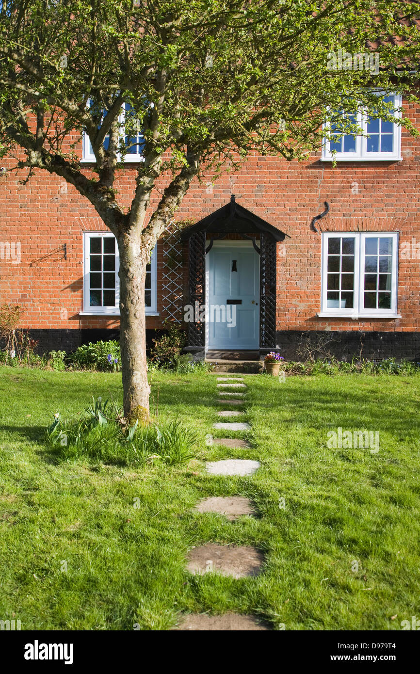 Garden path leading past apple tree to front door of house, UK Stock Photo