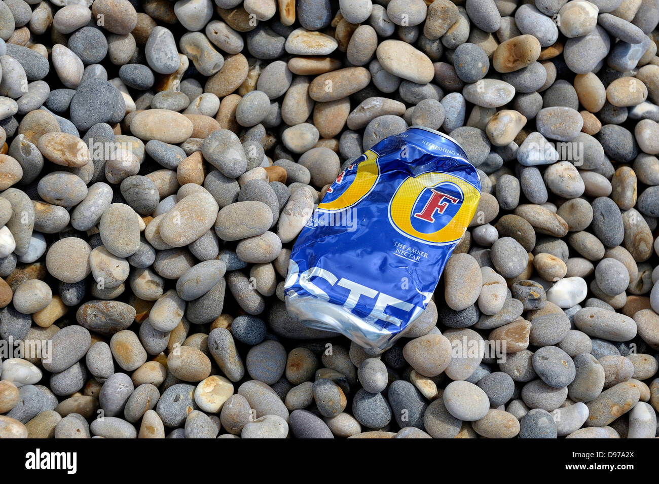 Empty beer can left on a pebble beach england uk Stock Photo