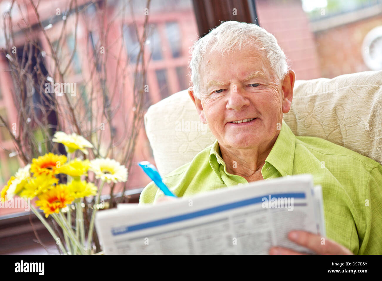 Seventies Man Active Retirement Lifestyle - Relaxing with Newspaper Stock Photo