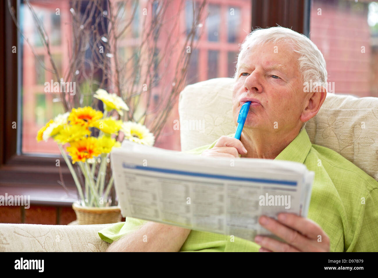 Seventies Man Active Retirement Lifestyle - Relaxing with Crossword Stock Photo