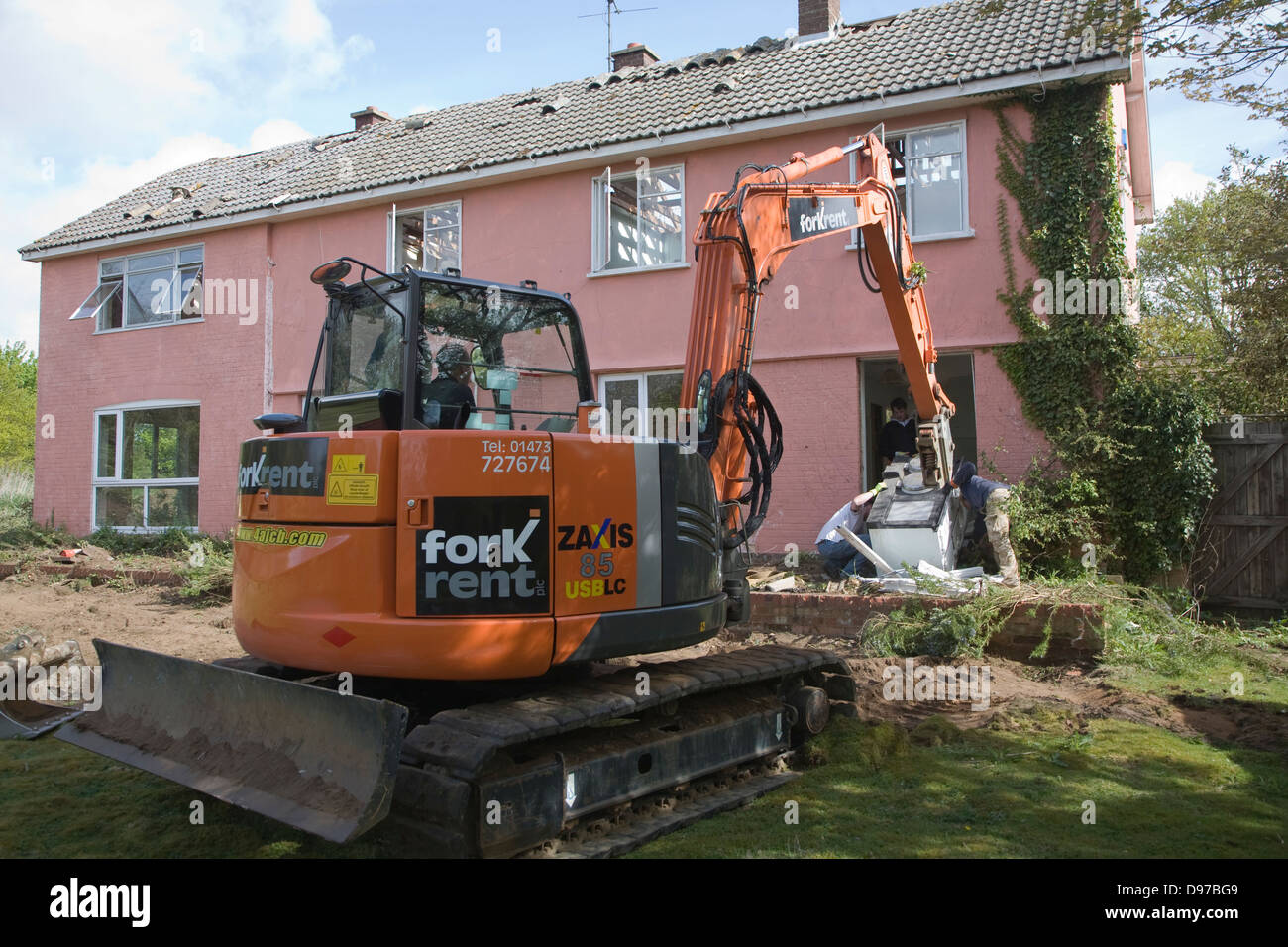 Crane and workmen removing Aga cooker from house about to be demolished