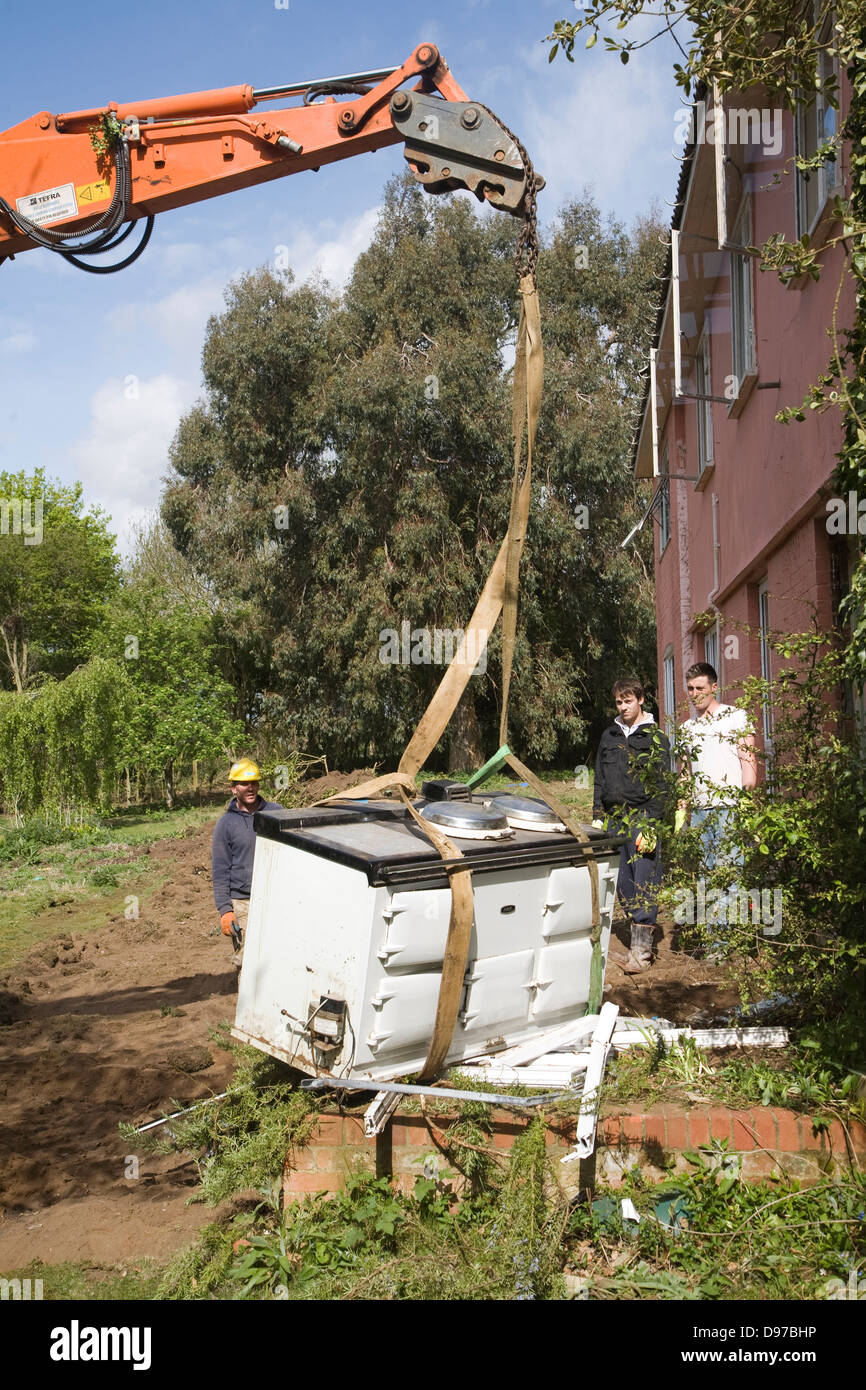 Crane and workmen removing Aga cooker from house about to be demolished