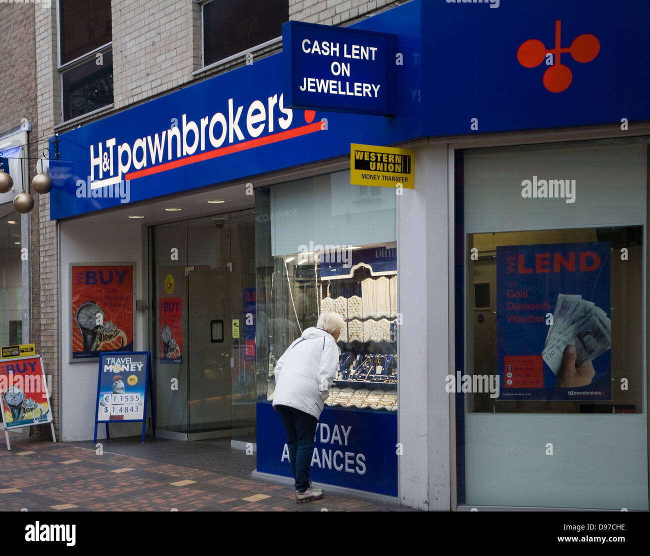 Woman looking in window of pawnbrokers shop Swindon, Wiltshire, England, UK Stock Photo