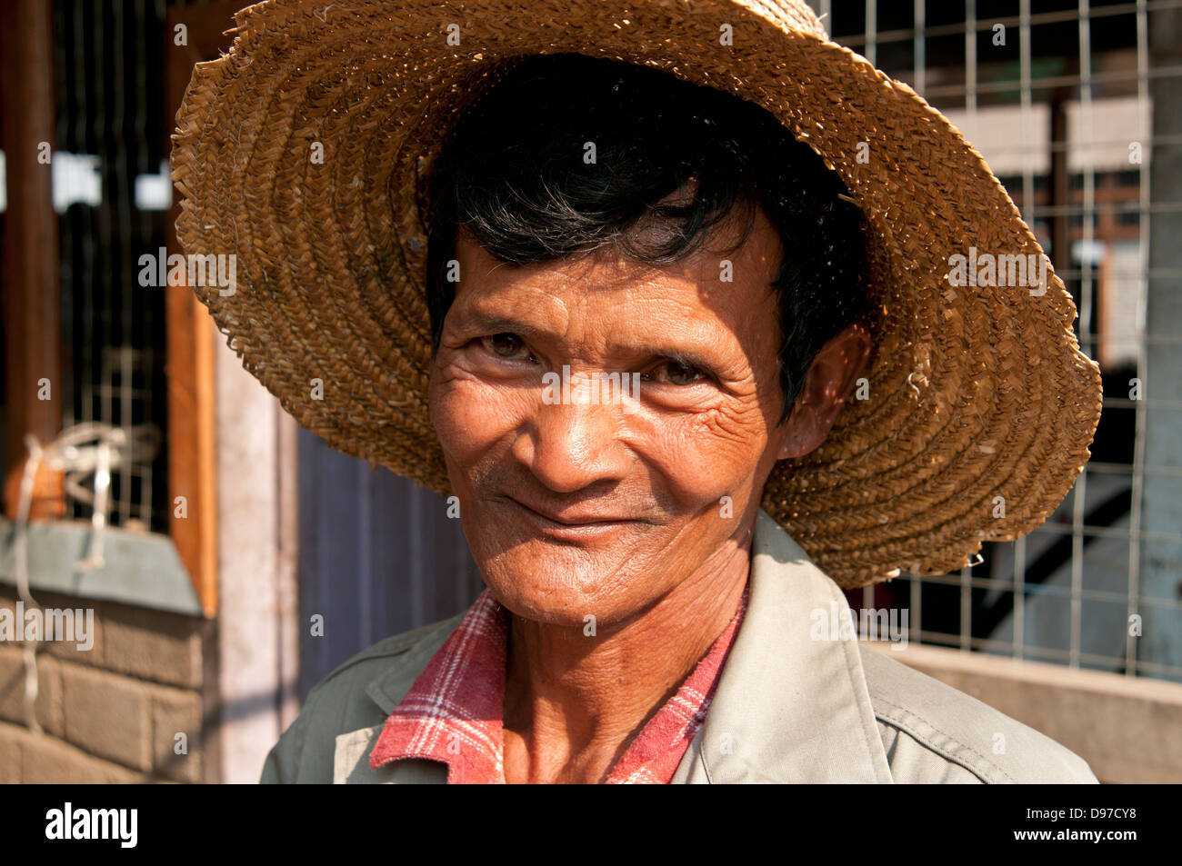 Man wearing a straw hat smiling at the camera in a market Myanmar (Burma) Stock Photo