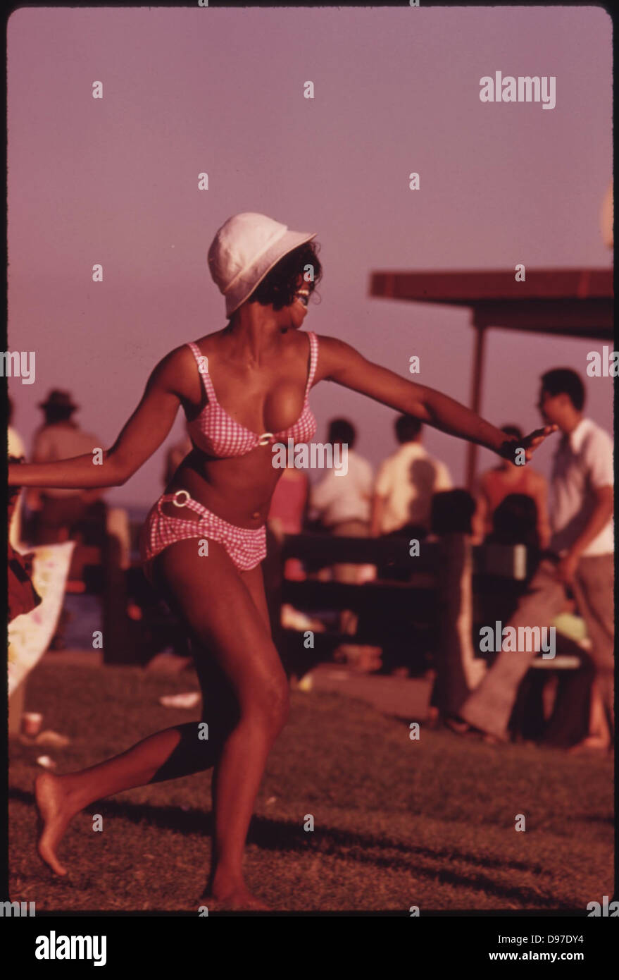 A Swimsuit Clad Black Woman Enjoys Her Summer Outing At Chicago's 12th Street Beach On Lake Michigan, 08/1973 Stock Photo