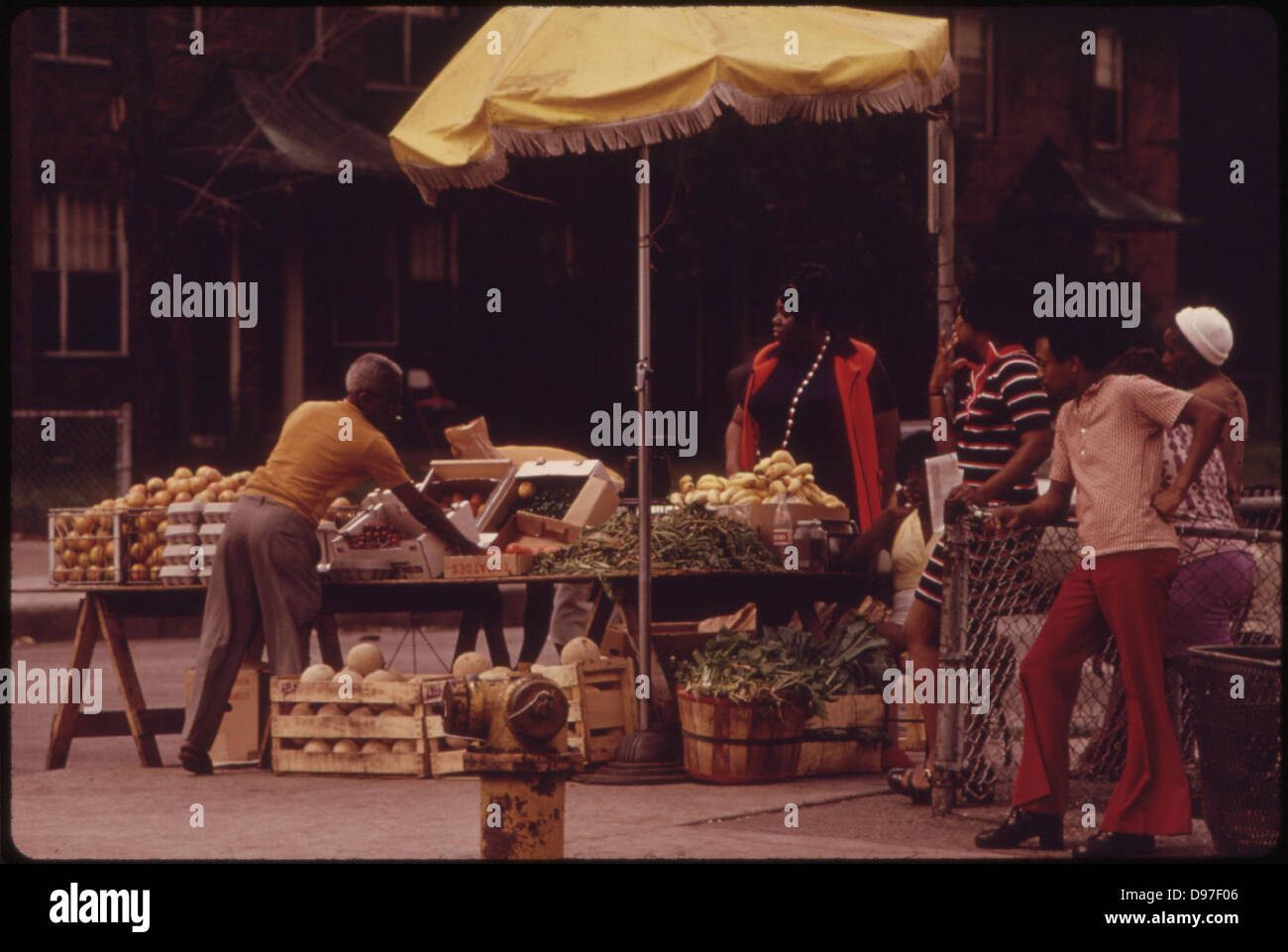 Black Sidewalk Salesmen Arranging Their Fresh Fruits And Vegetables On Chicago's South Side, 06/1973 Stock Photo