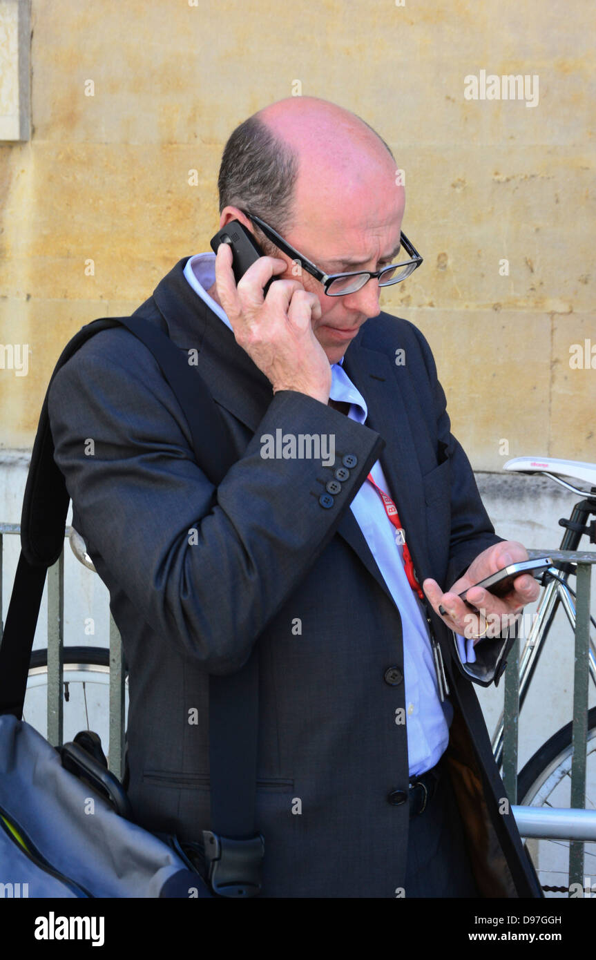 Nick Robinson British journalist and a BBC political editor using mobile phones outside Portland Place HQ London England UK Stock Photo