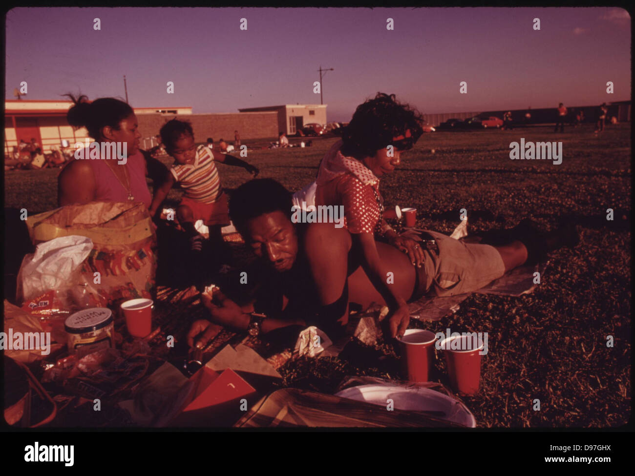 Black Family Enjoys A Picnic During The Summer At Chicago's 12th Street Beach On Lake Michigan, 08/1973 Stock Photo