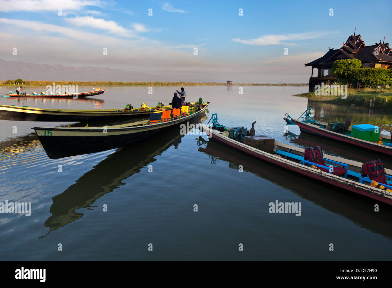 Boats moored by the Lake Inle Resort at sunset, Myanmar Stock Photo