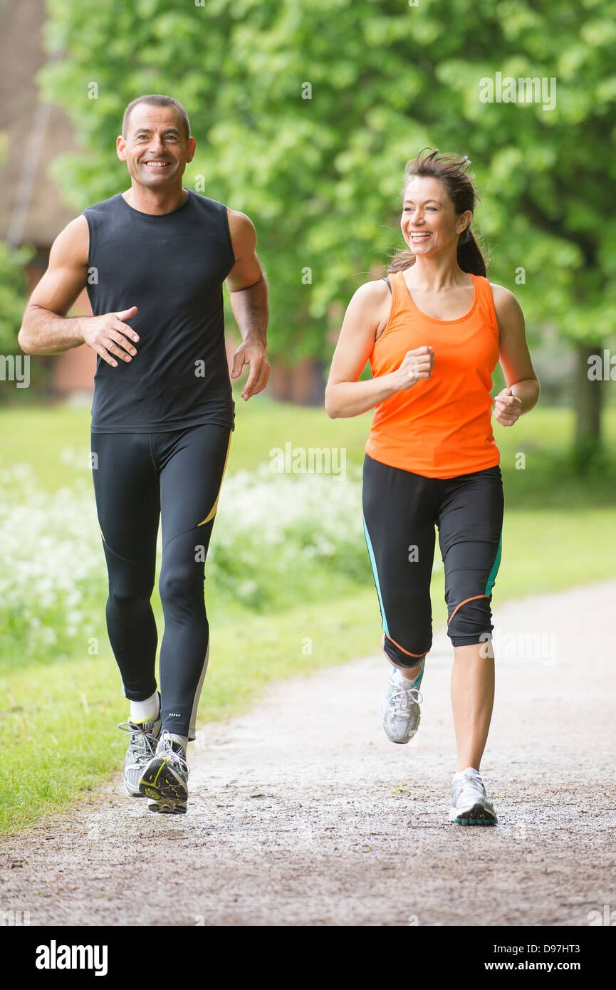 Sport couple running in park Stock Photo - Alamy