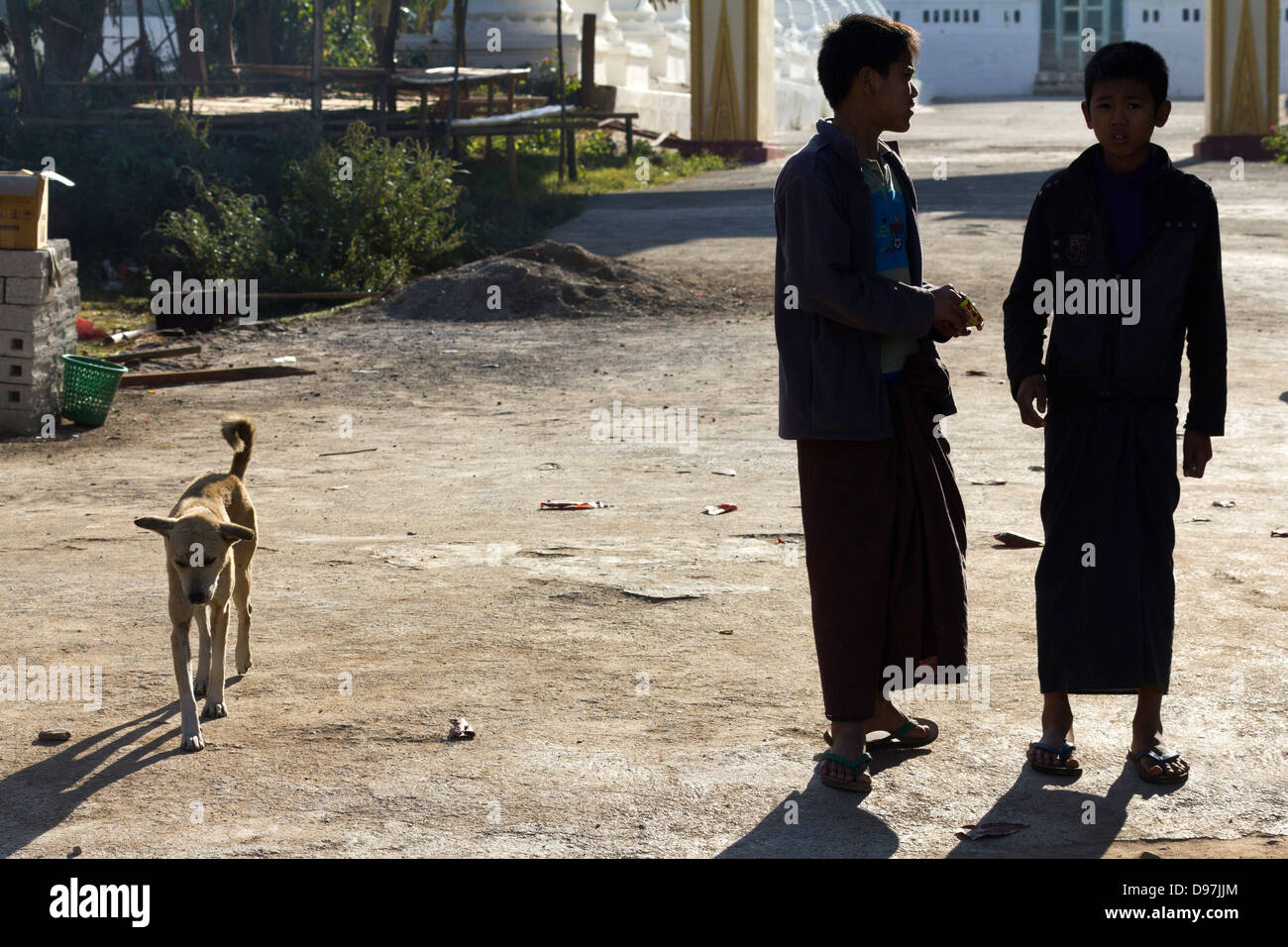 Two boys and a dog in a small village by Lake Inle, Myanmar Stock Photo
