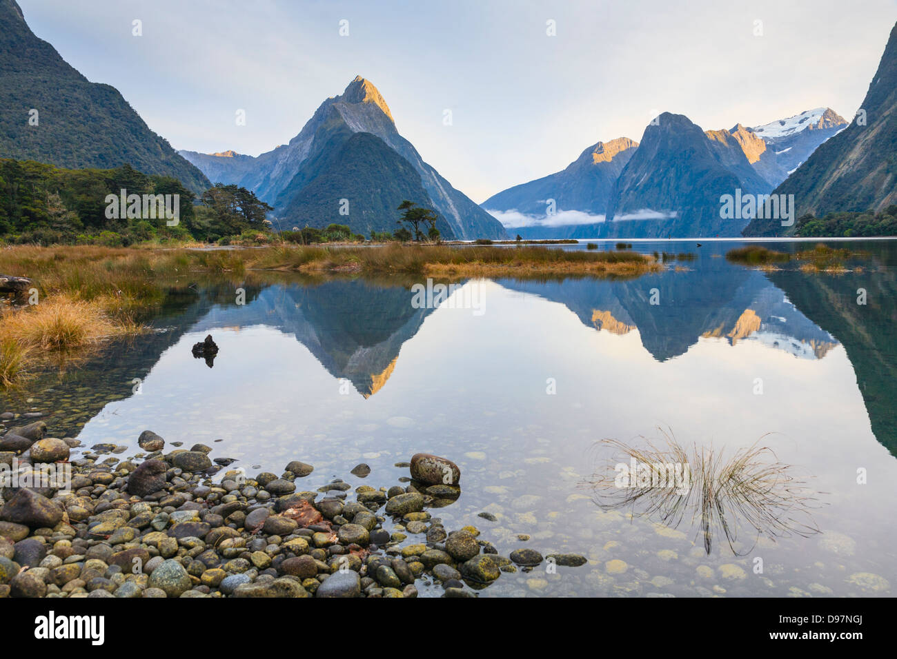 First light on Mitre Peak and surrounding mountains at Milford Sound, Fiordland, in New Zealand's South Island. Stock Photo