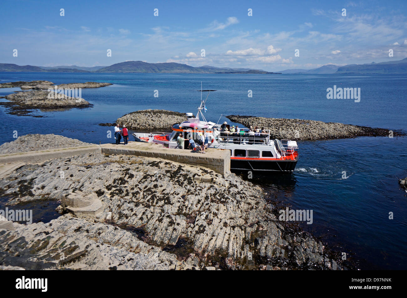 Passengers are embarking motor vessel Ullin of Staffa at Staffa pier Inner Hebrides Scotland to return to Iona. Stock Photo