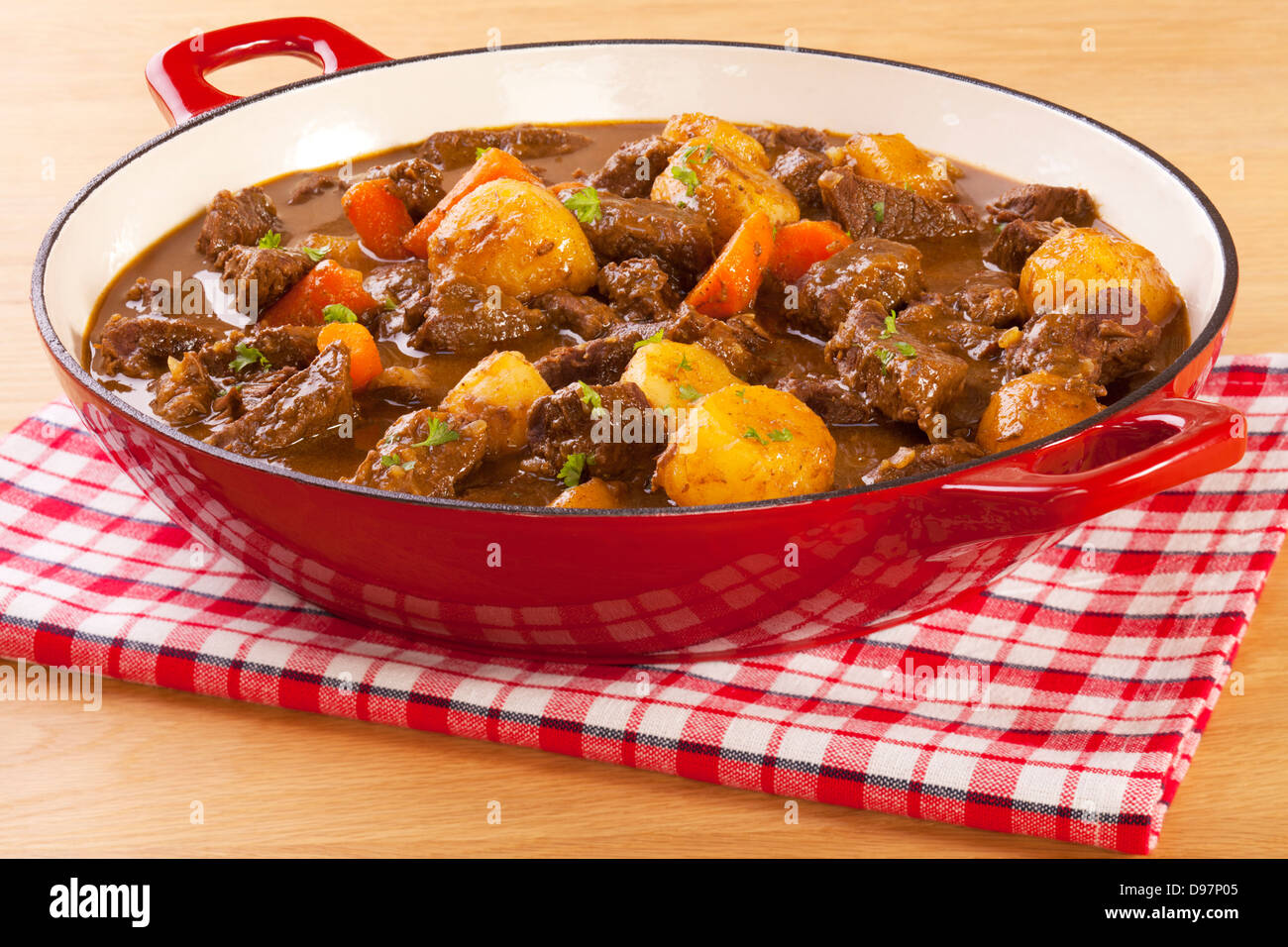 Stew with Carrots and Potatoes - a simple stew in a red pot, with carrots and potatoes. Stock Photo