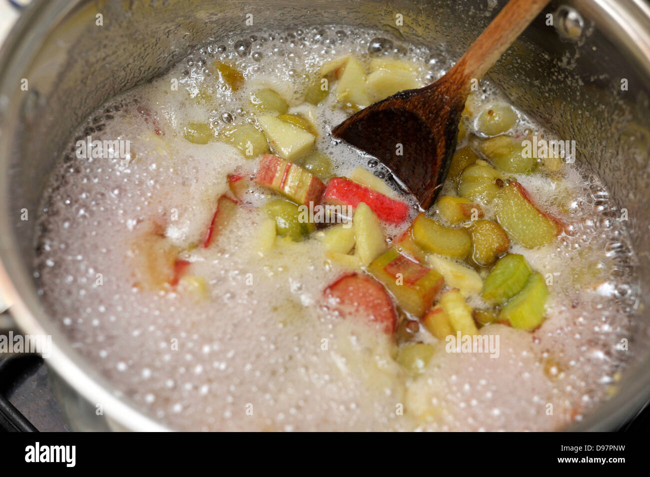 Homemade jam making with rhubarb, gooseberries and a little apple coming to the boil. Stock Photo