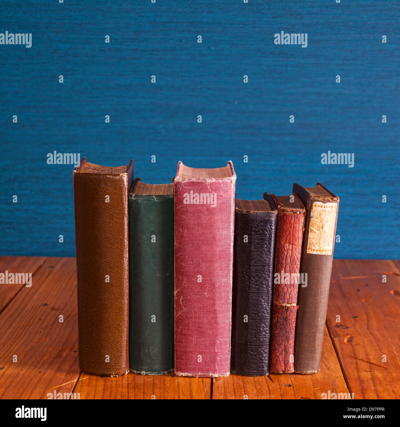 Old Books 0n Rustic Pine Table - old books standing on a rustic pine table with copy space above. Stock Photo