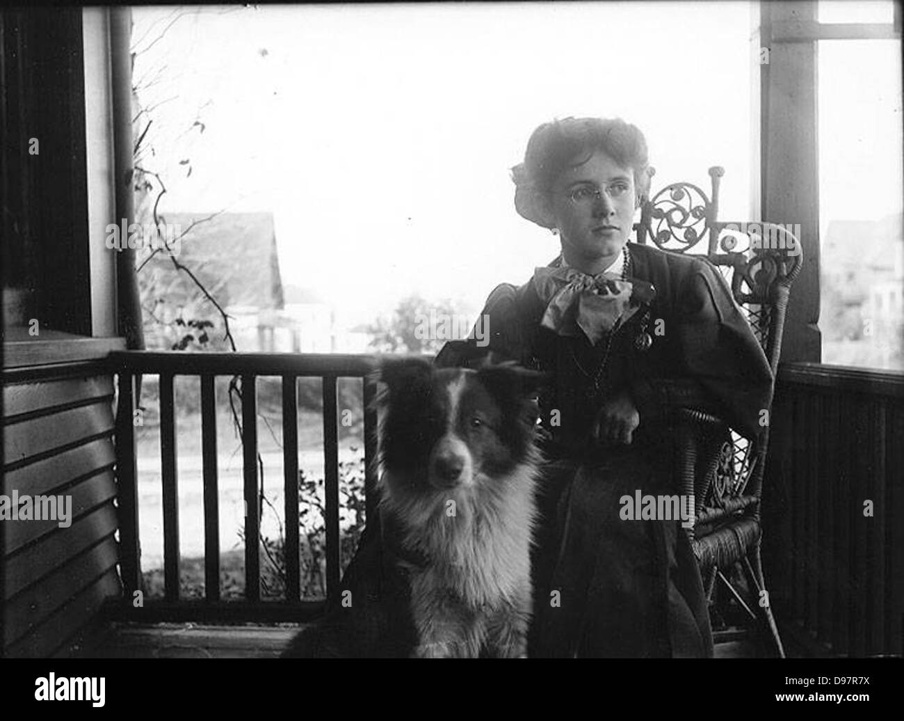 Unidentified woman sitting with dog on porch, Washington State Stock Photo