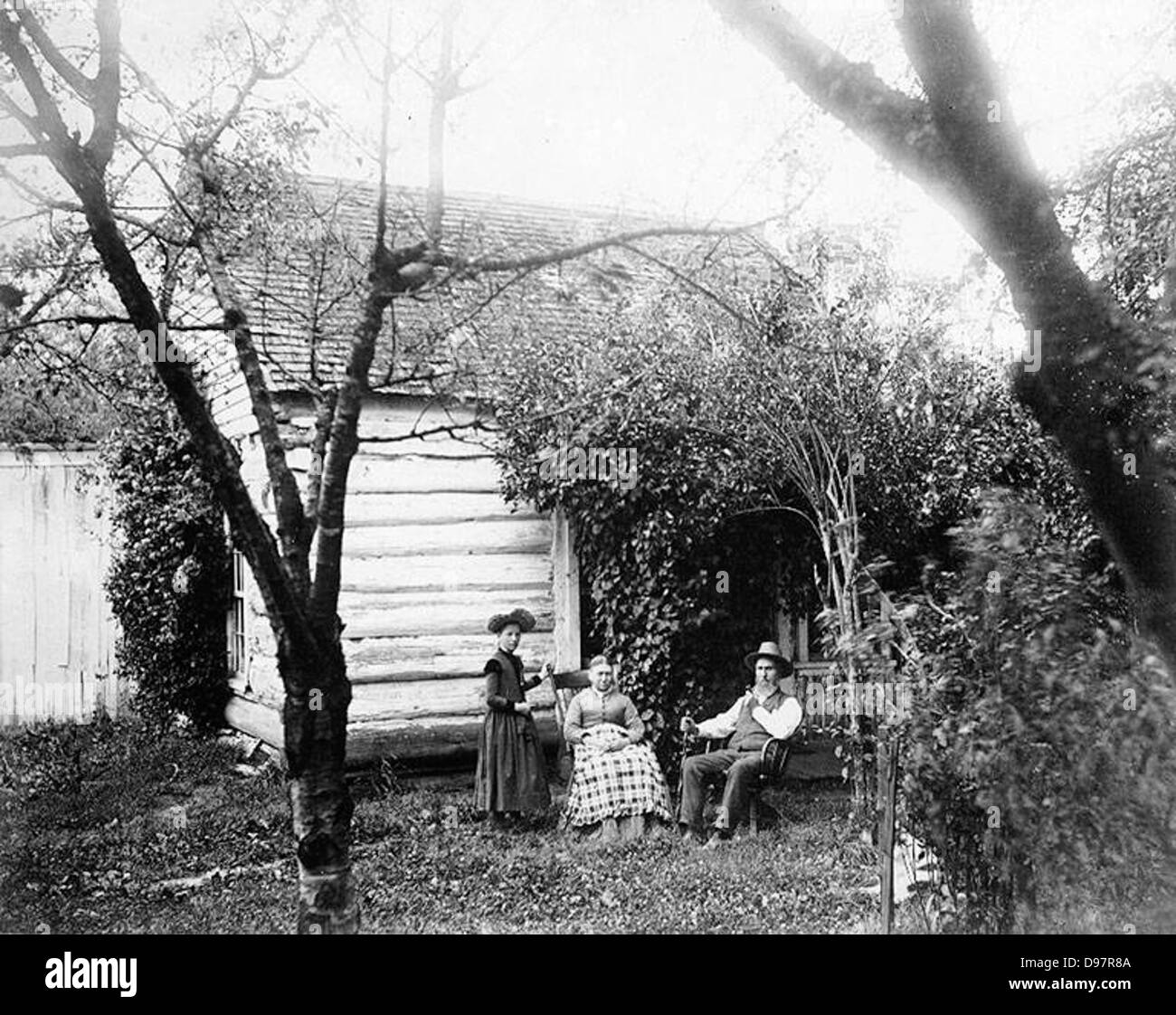 Homesteaders seated outside in garden surrounding house, probably Washington State Stock Photo