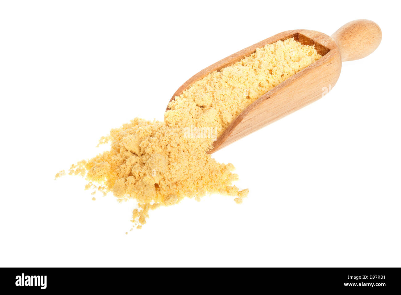 Mustard Powder - Yellow English mustard powder spilling from a scoop on a white background, front to back focus. Stock Photo