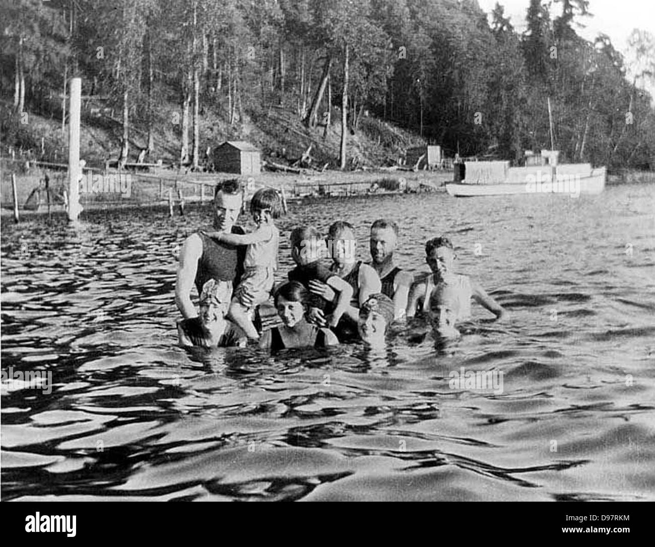 This image shows people bathing and swimming at Burrows Landing in Lake Washington, Bellevue, Washington, capturing a family outing on the water in the mid-20th century. Stock Photo