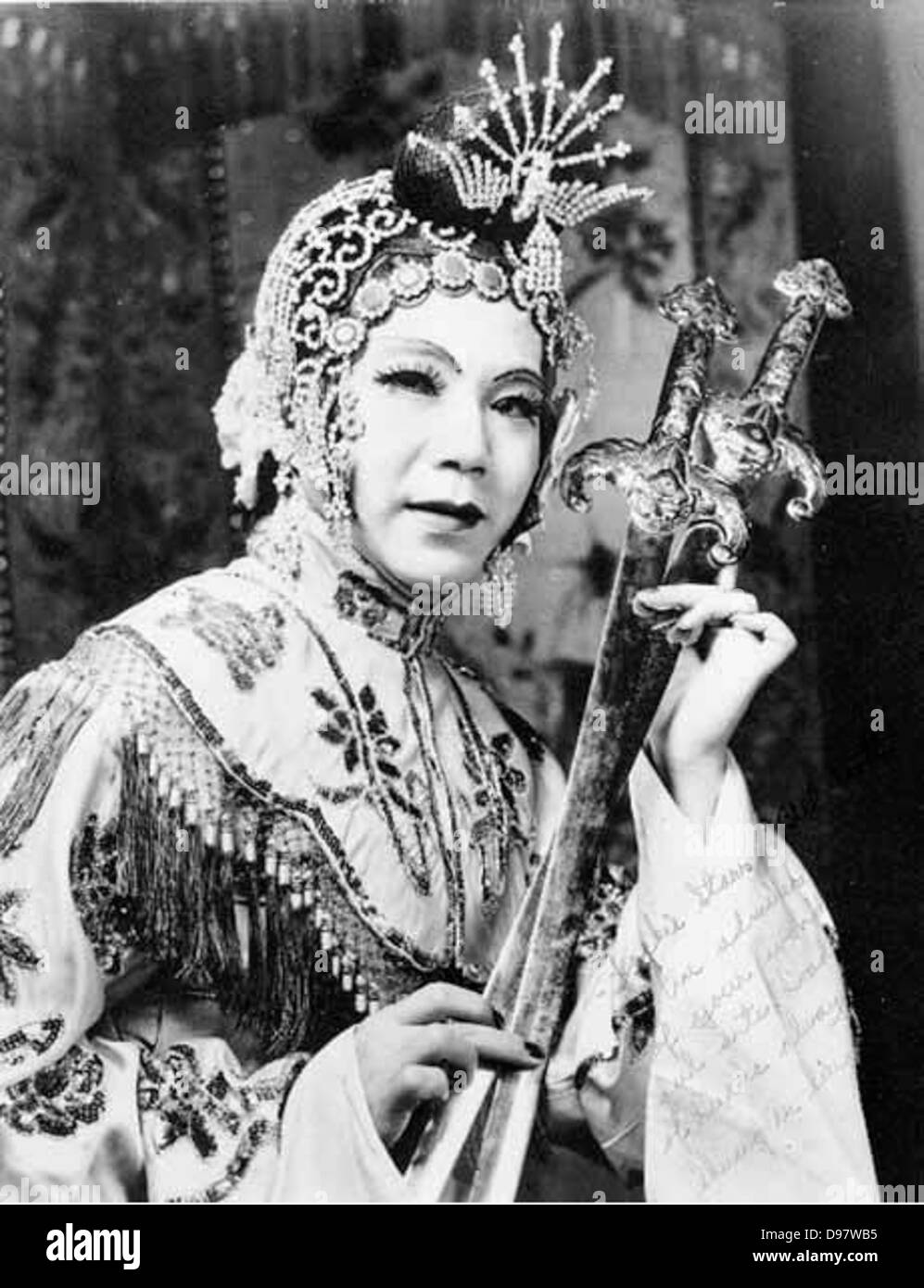 This promotional photograph features Shuug Au Sing, a Chinese American artist, holding two swords. The image captures the martial artist in a dynamic pose, promoting his performance in the Chinese Musical Club. Stock Photo
