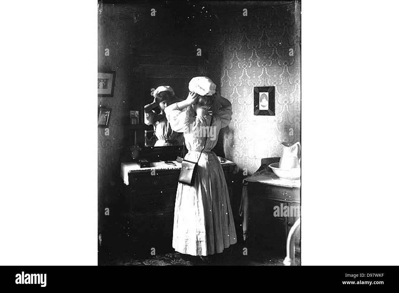 Unidentified woman trying on hat in front of mirror, Washington Stock Photo