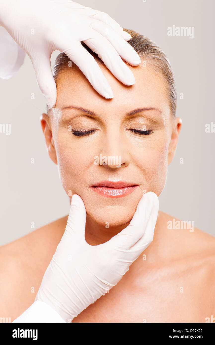 plastic surgeon checking middle aged womans face after operation Stock Photo Alamy
