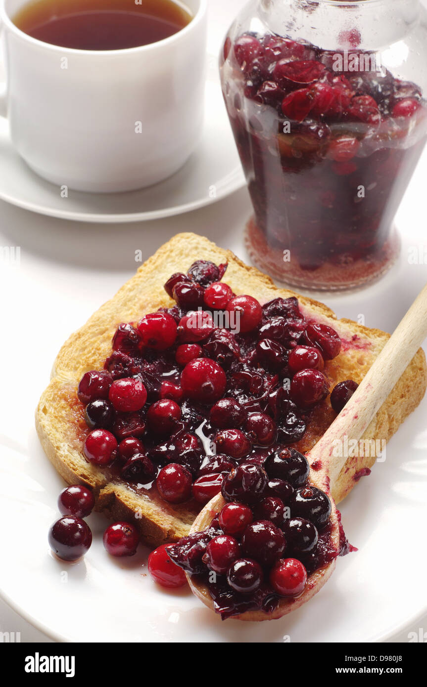 Toast with cranberry jam, jar and cup of tea Stock Photo