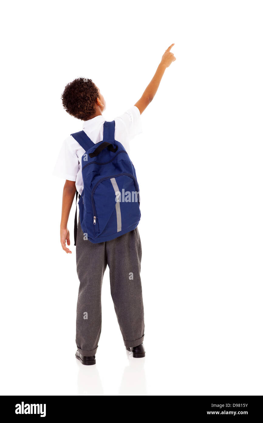 little schoolboy with schoolbag pointing at empty copy space Stock Photo