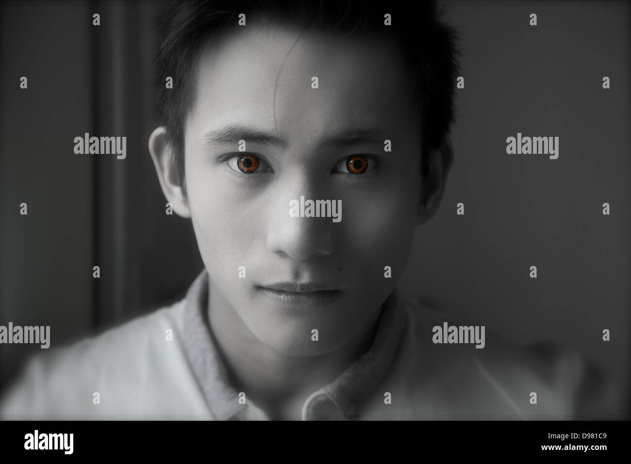 Young man with coloured contact lenses, looking at camera, England